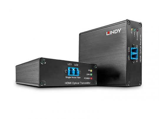 Two black metal LINDY 38063 High Speed HDMI Optical Extender devices—one labeled Transmitter, the other Receiver—are displayed side by side on a white background. Each unit has fiber optic ports, HDMI connectors, and indicator LEDs. These new Lindy HDMI Extenders transmit high-speed video over long distances using fiber optic cables.