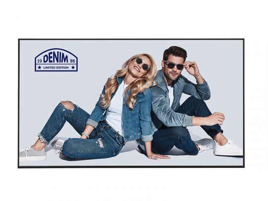 A smiling man and woman wear matching denim outfits and sunglasses, sitting casually on the floor against a light background. A Denim Limited Edition label appears in the top left corner, highlighting their stylish and relaxed fashion.