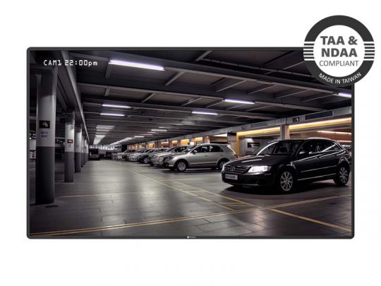 Surveillance monitor showing clear footage of a well-lit parking garage with multiple parked cars, featuring a TAA & NDAA Compliant badge in the top right corner and a timestamp reading CAM1 22:00pm—ideal for secure video surveillance systems.