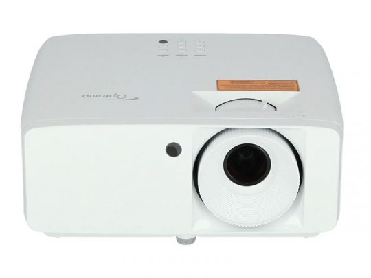 Optoma projector front view – A white Optoma projector with a prominent lens on the right, top control buttons, and an orange warning label near the lens. The image shows the device photographed from the front against a plain background.