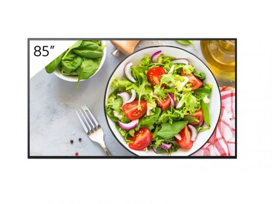 85-Zoll-Bildschirm (zum Mieten oder Kaufen) zeigt ein Bild von frischem Salat mit Kopfsalat, Spinat, Tomatenvierteln und roten Zwiebeln in einer Schüssel. Daneben liegen eine Gabel, eine kleine Schale mit Spinat und ein Karaffe Olivenöl auf heller Oberfläche. Ideal für Präsentationen oder Events.