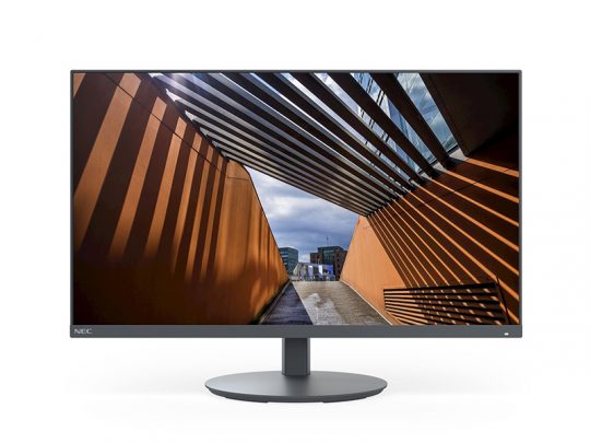 Moderner Computer-Monitor mit dünnem Rahmen und rundem Standfuß zeigt ein Foto eines überdachten Außenwegs mit orangen Wänden und Sonnenstrahlen, die Streifenschatten werfen; im Hintergrund heller Himmel mit Wolken. Ideal für Büro oder Homeoffice.
