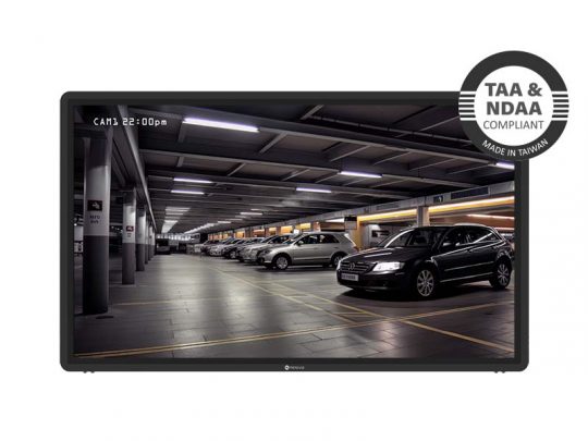Monitor zeigt Überwachungsaufnahmen eines hell erleuchteten Parkhauses mit geparkten Autos; oben rechts ist ein runder Badge mit der Aufschrift "TAA & NDAA konform, Made in Taiwan" zu sehen. Das Produkt eignet sich ideal als Sicherheitsmonitor für Parkhäuser und erfüllt internationale Sicherheitsstandards.